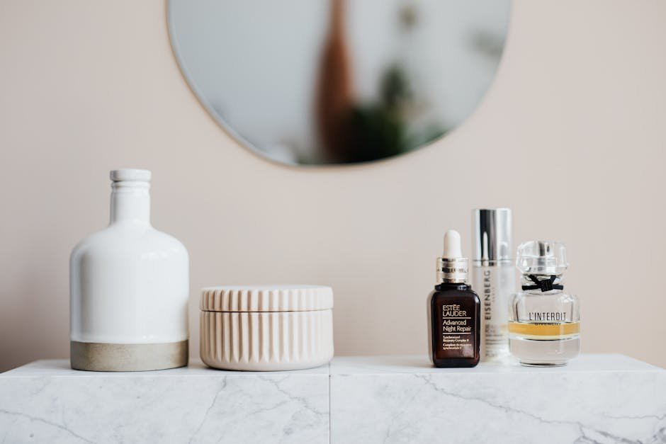 Stylized skincare and cosmetic bottles on a marble shelf with mirror reflection.